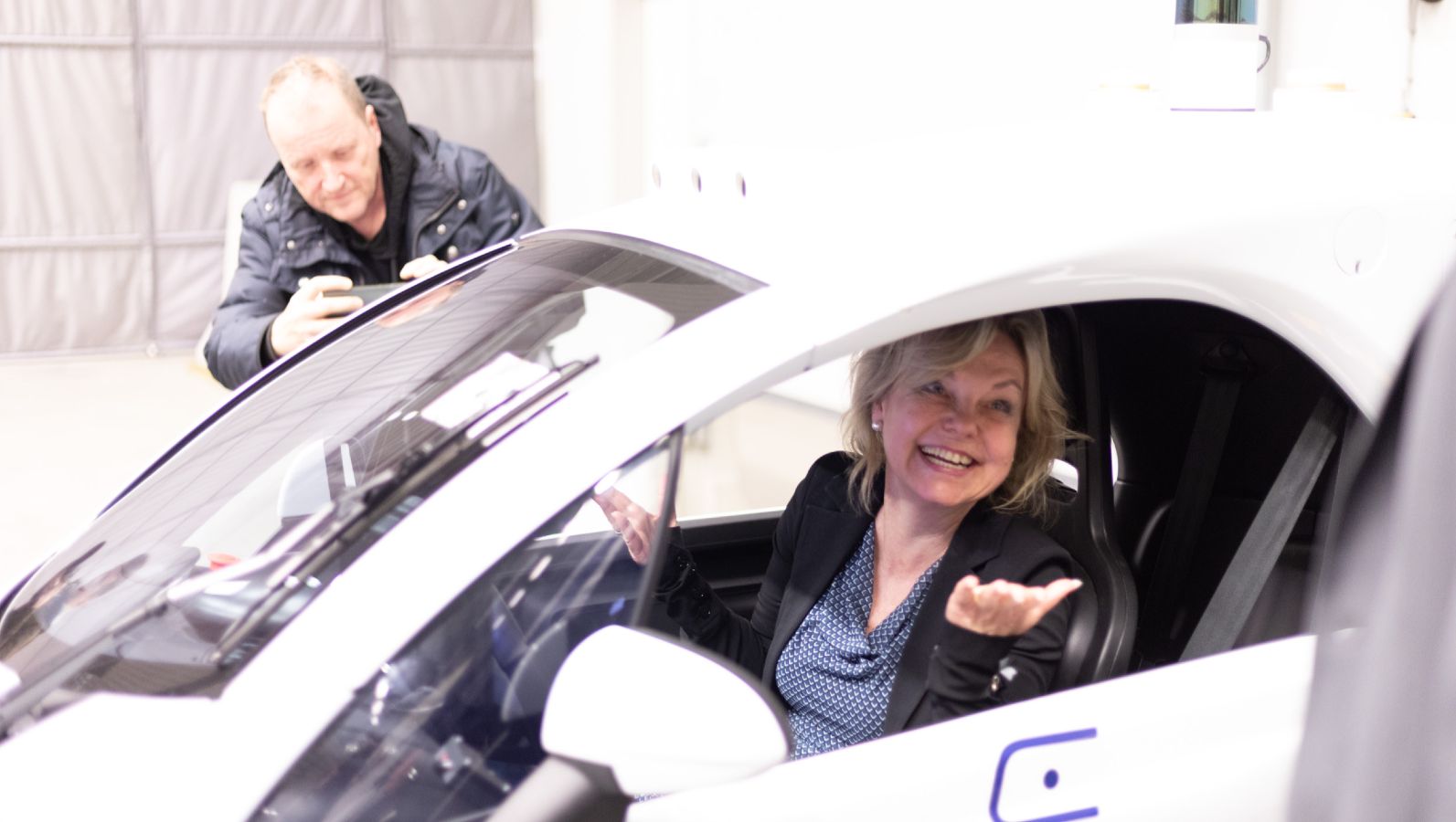 Staatssekretärin Sabine Döring sitzt lachend in einem Auto